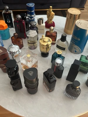Samling av exklusiva herrparfymer - Stor samling herrparfymer i unika flaskor med olika former och färger, bland annat guld, blått, svart, grönt och transparent. Flera flaskor har kreativa designer som metall, glas och plast. Perfekt för dig som vill ha variation och snygga flaskor i badrumshyllan.