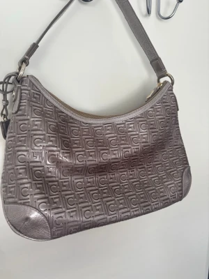 Vintage Liz Claiborne shoulder bag 🤎✨ - Snygg vintage axelväska från Liz Claiborne i en taupe/brunbeige ton med coolt mönster och guldfärgade detaljer.  Väskan har en riktigt fin Y2K/vintage-look och passar perfekt till både jeans, kjol och en mer classy outfit. 🤎  • Märke: Liz Claiborne • Färg: taupe/brunbeige • Guldfärgade detaljer • Dragkedjestängning • Innerfack med dragkedja • Justerbart/axelrem • Vintage  Skick: Fint vintage skick. Det finns normala tecken på användning