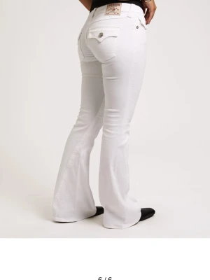 Vita bootcut jeans med fickdetaljer - Säljer ett par hela nya vita bootcut jeans med snygga fickdetaljer och silverknappar bak i storlek 28w. Jeansen har en klassisk femficksmodell och utsvängda ben. Perfekta för dig som vill ha en clean och fräsch look med lite retrovibbar. Säljer för att ja köpte fel storlek. Priset kan diskuteras ❤️