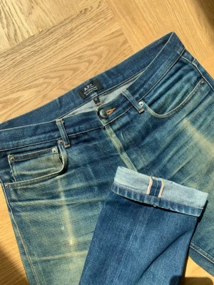 A.P.C Selvedge Jeans - Riktigt snygga selvedge jeans från A.P.C med en väldigt snygg patina samt honeycombs som utformats naturligt efter användning. Notera mindre fläckar på benen, skriv vid frågor. Storlek 30 - utgå från angivna mått. Modellen är 178 cm lång och väger 65 kg.  Mått  Midja: 41 Ytterben: 107 Innerben: 85 Benöppning: 18  Skriv vid frågor eller funderingar!