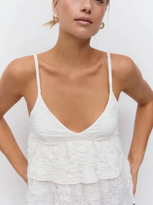 Vit volangtop från Gina Tricot - Säljer en söt vit linnetopp från Gina Tricot storlek S med tunna axelband och v-ringning. Toppen har dubbla volanger framtill och är tillverkad i ett lätt, skrynkligt material som ger en avslappnad känsla. Knappt använd. 