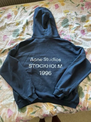 Acne studios hoodie blå - Tja! Säljer min feta acne studios hoodie i färg blå. Har bara använts hemma några få gånger. Den är i perfekt skick. Har en baggy/oversized look, passar extremt bra på de som gillar det. På size tagen står det storlek M men den passar mer som L - XL.  Hör av er vid frågor kring pris/ annat. Allt gott!!!