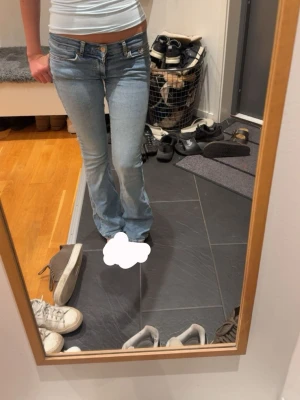 ljusblå lågmidjade bootcut jeans - ljusblå bootcut jeans från gina som jag sytt om till lågmidjat, inga andra defekter förutom lite slitage längst ned (sista bilden) ganska stretchiga och har en bra passform och är bekväma, skriv för fler bilder eller frågor!!