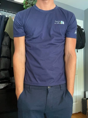 Mc2 Saint Barth T-shirt - Marinblå M - Säljer en stilren blå t-shirt från Mc2 Saint Barth med ett diskret broderat motiv på bröstet och logga på ärmen. En premium t-shirt som passar perfekt till både vardag och sommar. Den är i nyskick och storleken är medium men passar även en small. Skriv vid frågor eller bilder.