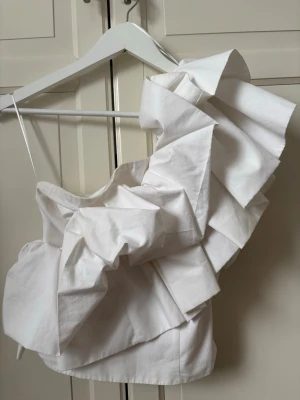 Zara volangtopp - Säljer en superfin vit topp från Zara. Oneshoulder topp med stora volanger. (Liten i storlek)🤍