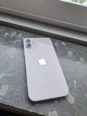 Vit iPhone med dubbla kameror - * 📱 Modell: iPhone 12 * 💾 Lagring: 64 GB * 🔋 Batterihälsa: 76 % * 📲 iOS 18.5 * 🔓 Olåst – fungerar med alla operatörer * 📦 Utloggad från iCloud och återställd 