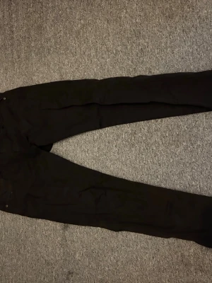 Svarta raka jeans - Säljer ett par svarta jeans med rak passform och klassisk femficksdesign. Jeansen har normal midja och stängs med knapp och dragkedja. Perfekta till en avslappnad stil och funkar året runt. W 32 L 32