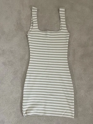 Randig kort klänning i beige och vit - Tight randig mini klänning