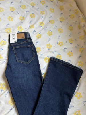 Superlow waist bootcut jeans - Snygga mörkblå bootcut jeans i klassisk femficksmodell med kontrastsömmar och superlåg midja. Jeansen har bootcut formade ben och stängs med knapp och dragkedja. Säljer även likadana först i svart demon.  