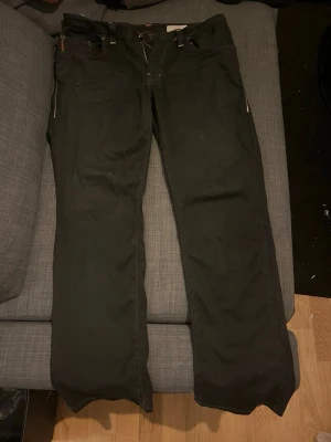 Svarta slim fit jeans från BOSS - Snygga svarta slim fit jeans från BOSS med klassisk femficksmodell och orangea sömmar. Jeansen har dragkedja och knapp i midjan samt raka ben. Perfekta för dig som gillar en stilren och modern look.