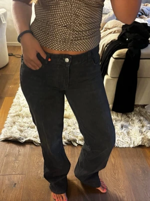 Svarta raka jeans - Säljer ett par svarta jeans med rak passform. Jeansen har klassisk femficksdesign och stängs med knapp och dragkedja. Materialet är denim i bomull och de har en tidlös look som passar till det mesta.