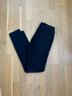 New Look svarta skinny jeans strl 38 - Svarta skinny jeans från New Look. Modell Supersoft Skinny med stretch – mjuka och följsamma med smal passform hela vägen ner.  Storlek UK 10 / EU 38.  Material: 62% bomull, 36% polyester, 2% elastan. Begagnat skick, se bilder.