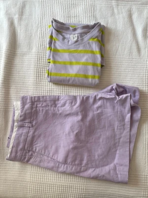 Sommaroutfit från Arket - T-shirt och shorts från Arket i naturmaterial. Lila/gul T-shirt i storlek S, har blivit lite nopprig men går säkert att få bort med en noppborttagare. Shortsen är i mycket bra skick och också i S.