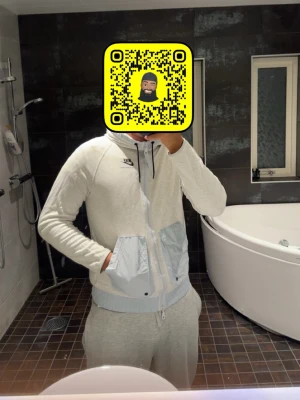 Nike ljusgrå hoodie med fickor sällsynt!! - Nike hoodie i ljusgrått med dragkedja, stor huva och två stora fickor framtill i ljusblått tyg. Svart Nike-logga på bröstet och ribbade muddar vid ärmslut och nederkant. Perfekt för en chill och sportig look.
