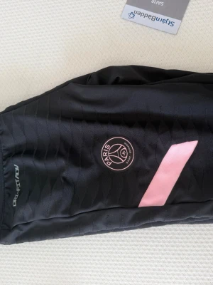 Svart PSG träningsbyxor från Nike - Snygga svarta träningsbyxor från Nike med PSG-loggan.
