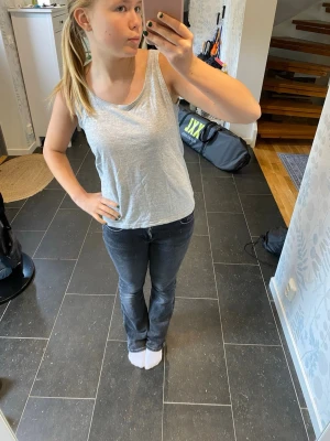 Ljusgrå ärmlös linnetopp - En enkel och stilren ljusgrå linnetopp i bomullsmix. Toppen är ärmlös med rund halsringning och har en avslappnad passform som passar perfekt till jeans eller shorts. Perfekt för varma dagar eller som lager under en skjorta.