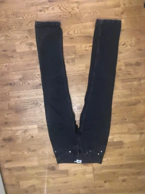 Svarta raka jeans med låg midja - Säljer ett par svarta jeans med rak passform och låg/mid rise midja. Jeansen sitter tajt i midjan tycker jag, de är långa på mig som är 168.
