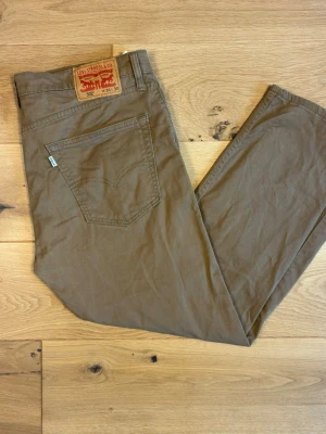 Khaki Jeans från Levi's - Snygga Levi’s 502 i khaki/olivgrön bomullstwill - ett skönt avbrott från vanlig denim. Rak/regular fit med klassisk femficksmodell och äkta läderlapp baktill.  •	Modell: Levi’s 502 	•	Storlek: W36 L30 	•	Skick: Några synliga fläckar, men bra använt  	 	•	Färg: Khaki/olivgrön 	•	Äkta läderlapp och röd Levi’s-etikett på bakfickan