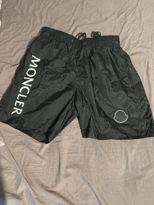 Svarta Moncler badshorts - Svarta Moncler shorts i M. Sitter som S. Kan användas som bad shorts och vanliga shorts