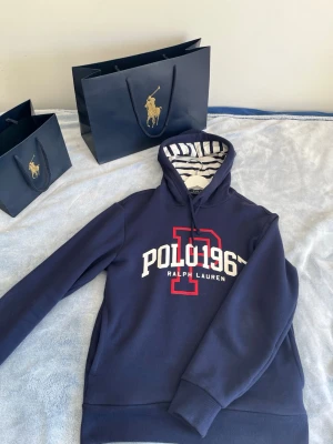 Marinblå💙 hoodie Polo Ralph Lauren - Snygg marinblå💙 hoodie från Polo Ralph Lauren med stor vit och röd logga 'POLO 1967' på bröstet. perfekt för en chill och sportig look🔥Ny pris  1899KR‼️ skriv vid minsta intresse. Priset är inte hugget i sten 🪨 