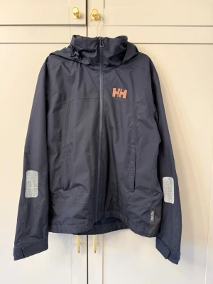 Helly Hansen Jacka Dam - Jacka från Helly Hansen Dam. Strl XL. I väldigt fint skick överlag och sparsamt använd. På bild 3 syns att det finns sminkrester på insidan av kragen vilket brukar gå att få bort.