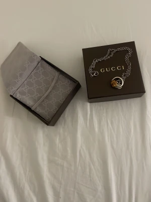 Gucci halsband med bambudetalj - Snyggt halsband, äkta från Gucci i silverfärgad metall med en unik bambudetalj och rund bricka med Gucci-logga. Kedjan är grov och ger ett coolt intryck. Kommer i originalask med Gucci-tyg. Perfekt accessoar för att lyfta din stil.