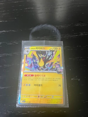 Pokémonkort på koreanska - Unikt Pokémonkort med färgstark design och koreansk text. Kortet har en gul ram och motiv av en elektrisk Pokémon med blixtar i bakgrunden. Levereras i plastficka för extra skydd. Perfekt för samlare eller Pokémonfans.