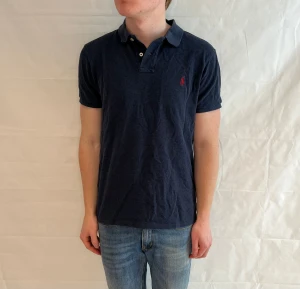 Polo Ralph Lauren Slim Fit Polo - Marinblå pikétröja i bomull, slim fit, begagnad i mycket gott skick.