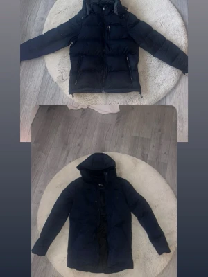 Två jackor  - Snygg två  svarta dunjackor med huva och dragkedja framtill. Jackan har två sidofickor med dragkedja och en puffig, quiltad design som håller värmen. Perfekt för kalla vinterdagar och har en klassisk, stilren look. Den andra är från peakperformanc