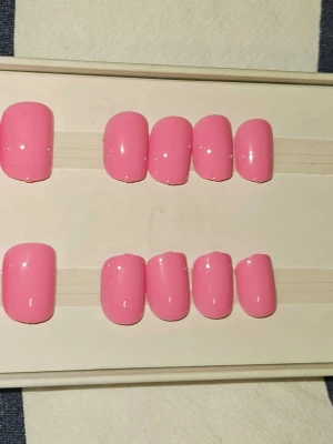 Bubblegum rosa press-on naglar - Snygga press-on naglar i en bubbelgumsrosa färg med extra kort, fyrkantig form. Perfekta för dig som vill ha en söt och fräsch look utan att behöva gå till salong. Lätta att applicera och ta bort.