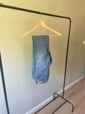 Nudie Jeans 👖  - Nudie Jeans – Strl 31/34 🔥 Ljusblå jeans från Nudie Jeans i klassisk femficksmodell. Stilren tvätt som passar till de flesta outfits. I fint begagnat skick.  📏 Storlek: 31/34 📦 Skick: Bra begagnat skick 💬 Hör gärna av dig vid frågor eller om du vill ha fler bilder!