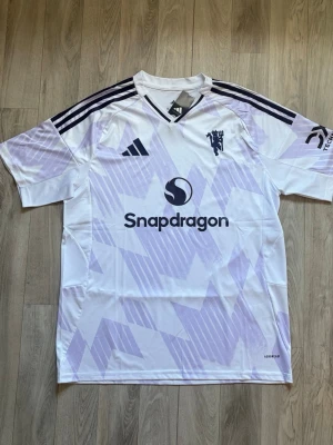  Manchester United  - Säljer en vit Manchester United matchtröja, bortastället från säsongen 26/26. Tröjan är i storlek XL men är slim fit så passar även för L. Tröjan är i toppen skick då den inte blivit använd och till och med har tag kvar.