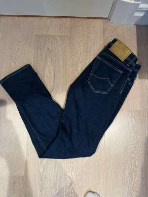 Mörkblå jeans från Jacob Cohën - Säljer ett par riktigt snygga jacob cohen jeans i modellen bard strl 32. Skicket är väldigt bra 9/10 och inga synliga defekter. Priset är heller inte hugget i sten så bara att skriva vid minsta lilla.