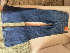 Blå bootcut jeans från Levi's - Säljer ett par klassiska blå bootcut jeans från Levi's med snygga kontrastsömmar och femficksmodell. Jeansen har en ikonisk röd Levi's-tag på bakfickan och är tillverkade i slitstarkt denimtyg. Perfekta för en avslappnad och trendig look.