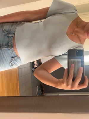 Ljusblå ribbad topp med puffärm - Supersöt ljusblå topp med v-ringning och puffiga korta ärmar. Toppen är ribbad och har en croppad passform som ger en trendig look. Perfekt att matcha med jeans eller kjol för en fräsch stil.