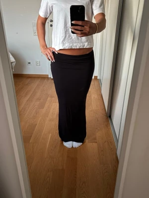 Lågmidjad lång kjol - Svart lång kjol som aldrig används. Den är väldigt stretchig så enkel att ha både som hög midja och låg🤩