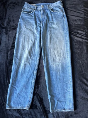 Ljusblå loose fit jeans - Säljer ett par ljusblå loose fit jeans med raka ben och klassisk femficksdesign. Jeansen har en avslappnad passform och är tillverkade i denim. Perfekta för en chill och trendig look. Storlek: 29W 32L