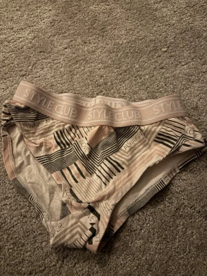 Mönstrade trosor från Style Club - Snygga trosor i ljusrosa och svart med grafiskt mönster och textdetaljer som 'LOVE' och 'ALWAYS'. Bred resår i midjan med Style Club-logga. Mjukt och stretchigt material för skön passform.