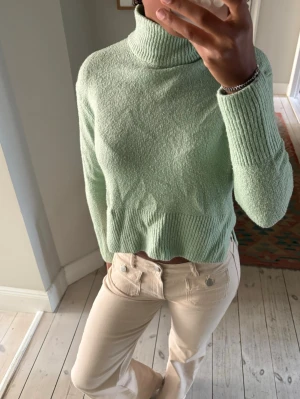 Mintgrön polotröja  - Snygg mintgrön stickad polotröja från Gina Tricot. Tröjan har ribbade muddar och polokrage, samt en något boxig och croppad passform. Perfekt för lager på lager och ger en fräsch look till din outfit. Storlek xxs men oversized så passar S/M!