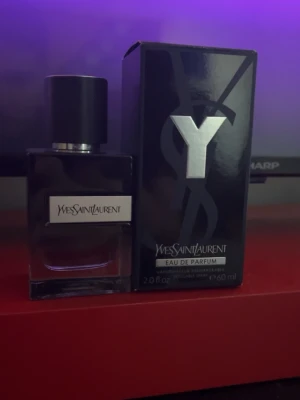 Yves Saint Laurent Y Eau de Parfum - Y Eau de Parfum från Yves Saint Laurent i en elegant, mörk glasflaska med svart lock och silverdetaljer. Flaskan har en stilren design och medföljande svart kartong med stor silverfärgad Y-logga. Volymen är 60 ml och typ 50-45 ml kvar, den är självklart äkta