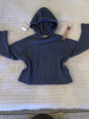 Blå hoodie från ZARA - Mysig blå hoodie från ZARA i mjukt stickat material. Tröjan har en stor huva och breda ribbade muddar vid ärmslut och nederkant. Perfekt för en chill och avslappnad stil. Passar till jeans eller mjukisbyxor.