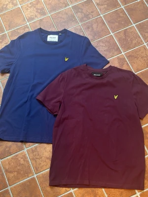 Två Lyle & Scott t-shirts blå & vinröd - Säljer två t-shirts från Lyle & Scott, en i marinblått och en i vinrött. Båda har storlek L och är använda någon enstaka gång. Är i väldigt bra skick. Hör av dig vid funderingar och pris kan diskuteras 