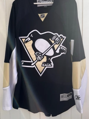 Pittsburgh Penguins - NHL - Officiell hockeytröja - Säljer en Pittsburgh Penguins-matchtröja. Tröjan är i väldigt bra skick utan några defekter som jag kan se. Officiell NHL-produkt från Reebok. Inget namn eller nummer på ryggen.  Storlek: Large  Kan erbjuda billigare frakt med frimärken. Tröjan kan även hämtas i Majorna i Göteborg.  #SHL #Sport #Hockey #Lemieux #Jagr #Sverige #Hockeybilder