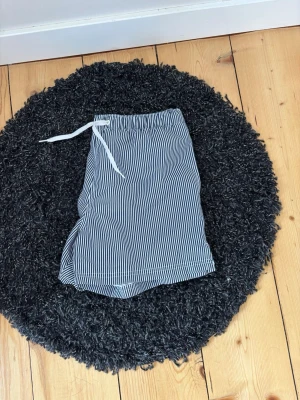 Randiga badbyxor från Frank Dandy - Snygga badbyxor från Frank Dandy i modellen Andy. De är blåvita med smala vertikala ränder och har vit dragsko i midjan. Innerbyxa i mesh för extra komfort. Perfekta för stranden eller poolen.