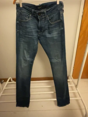 Mörkblå slim fit jeans Jack & Jones - Snygga mörkblå slim fit jeans med klassisk femficksdesign och lätt slitningar framtill. Jeansen har normal midja och raka ben, perfekta till en avslappnad stil. Tillverkade i mjukt denimtyg för skön känsla. Skriv vid minsta fundering. W27 L32