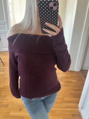 Vinröd off shoulder stickad tröja - Mysig vinröd stickad tröja med bred ribbad kant och off shoulder-modell. Tröjan har lång ärm och en kroppsnära passform som ger en snygg siluett. Perfekt att matcha med jeans för en trendig look. Aldrig använd! Skriv för mer info🫶🏻