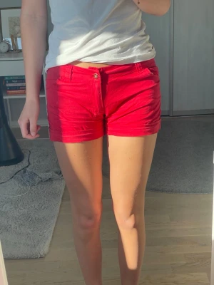 Röda low waisted shorts! - Snygga low waisted röda shorts! Shortsen har både fram- och bakfickor samt knapp och dragkedja framtill. Perfekta för varma dagar och enkla att matcha med olika toppar.