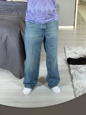 Blå baggy jeans från Cos - Säljer ett par ljusblå baggy jeans med rak passform och klassisk femficksdesign. Jeansen har hög midja och är tillverkade i denim med en avslappnad look. Köpta från Cos och använde 1 gång och ångrade köpet direkt då de var lite för baggy för min smak. Jag är 177cm och väger 72kg bär storleken W29 L32