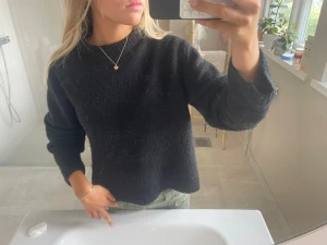 Svart stickad tröja  - Mysig svart stickad tröja med rund hals och långa ärmar. Tröjan har en avslappnad passform och ribbstickade muddar vid ärmslut och nederkant. Perfekt att matcha med jeans eller kjol för en enkel och stilren look. Från Gina tricot, aningen nopprig därav lågt pris 