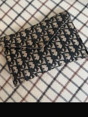 Dior clutch  - Snygg kuvertväska från Dior. Använd fåtal gånger och är i super fint skick förutom två pytte små fläckar som säkert går bort men inte alls syns när man använder väskan💕